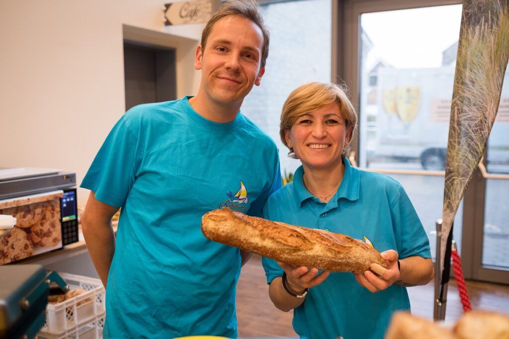 Ein Mann und eine Frau posieren mit einem großen Laib Brot.
